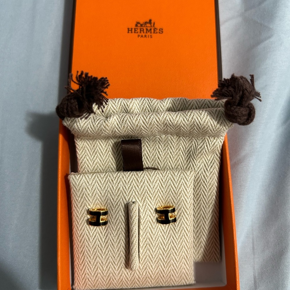 Brand new, small Hermes stud earrings in black and gold